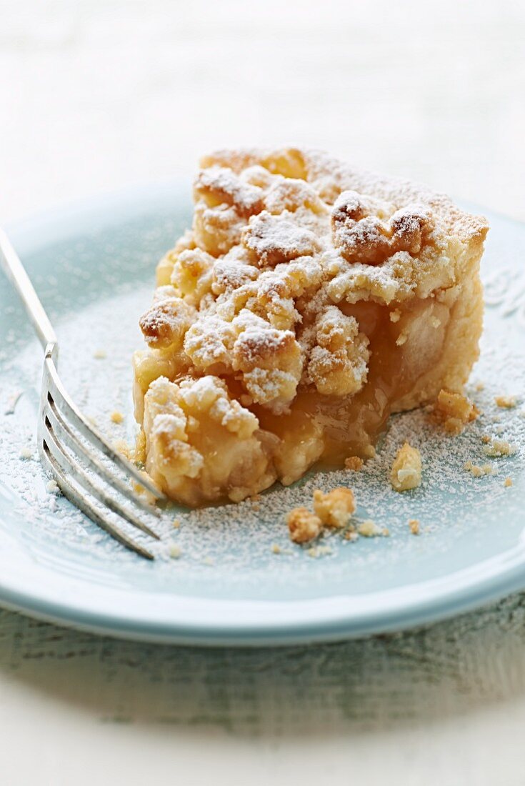 A slice of apple tart with coconut crumbles