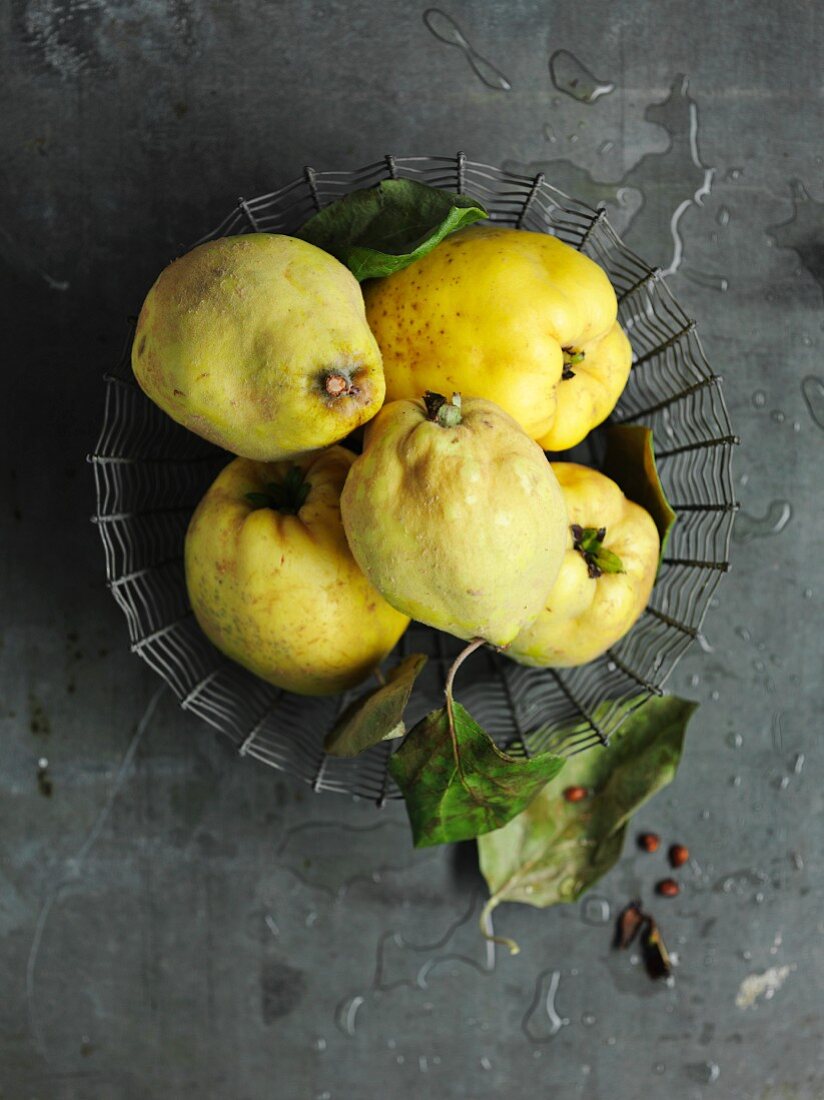 Quinces with leaves in a wire basket