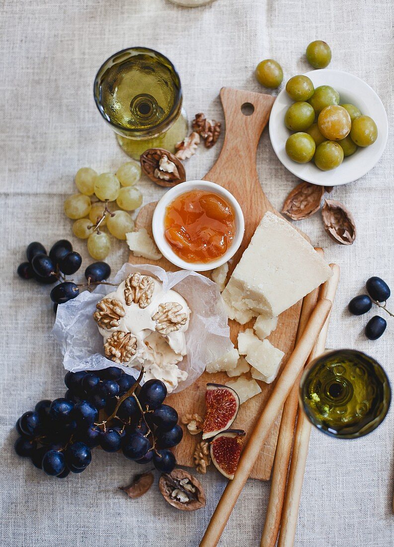 Käseplatte mit Trauben, Feigen, Nüssen, Marmelade, Grissini und Wein