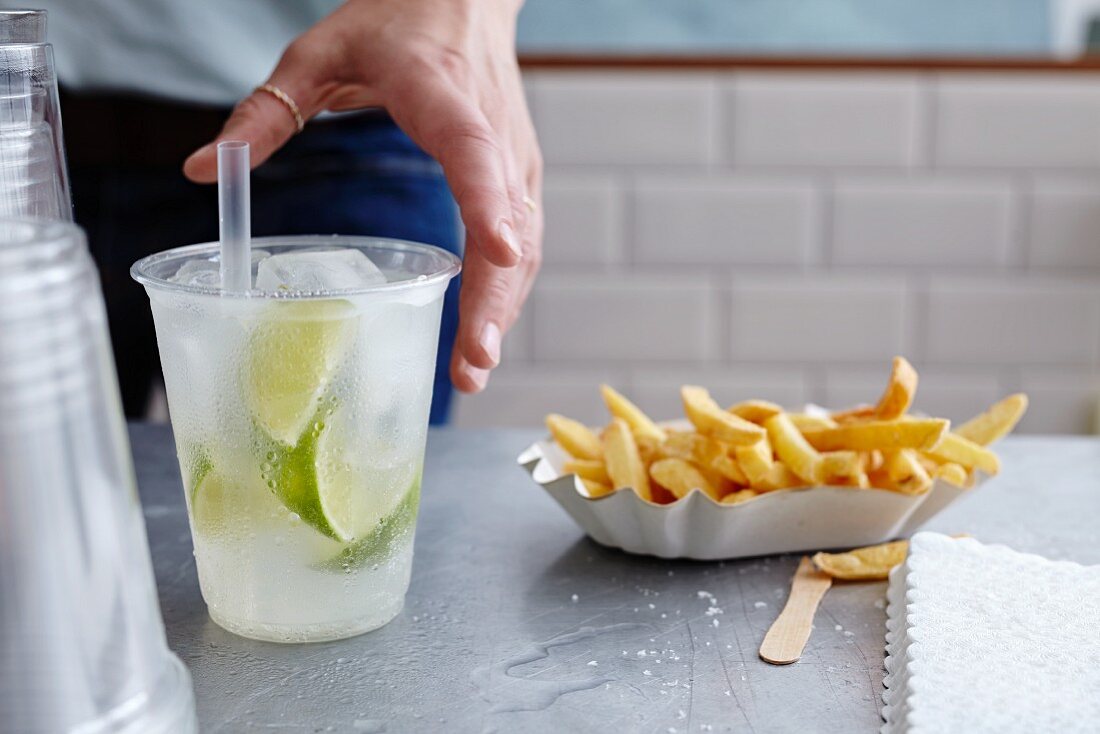 Pommes in Pappschälchen & Getränk in Plastikbecher