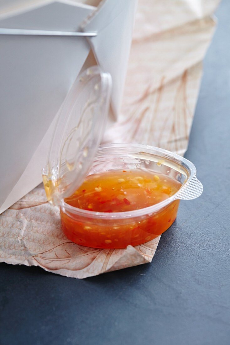 Sweet chilli sauce in a plastic bowl
