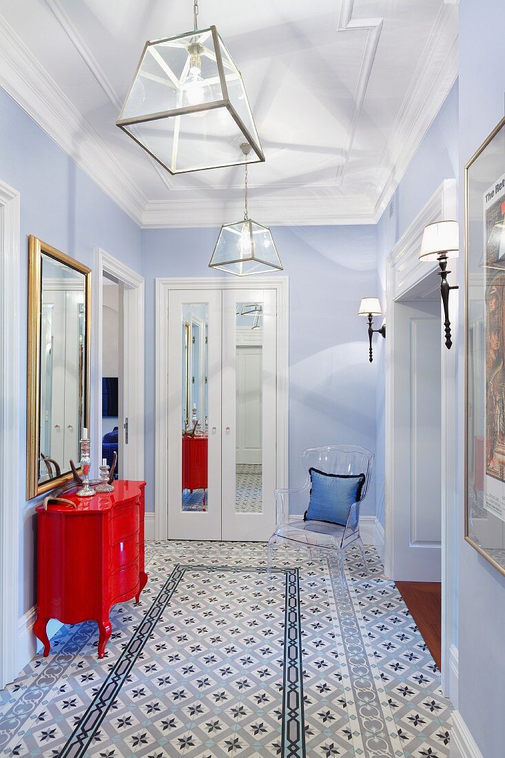 Hallway with patterned tiled floor, pale blue walls and red, postmodern chest of drawers