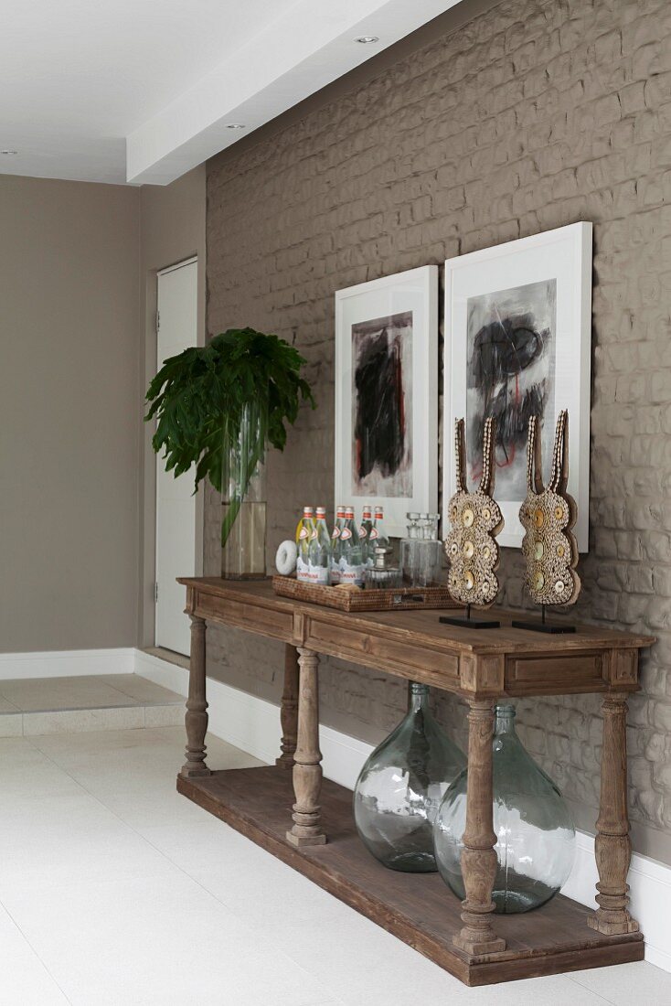 Rustic console table with turned legs against wall painted mud brown in modern foyer