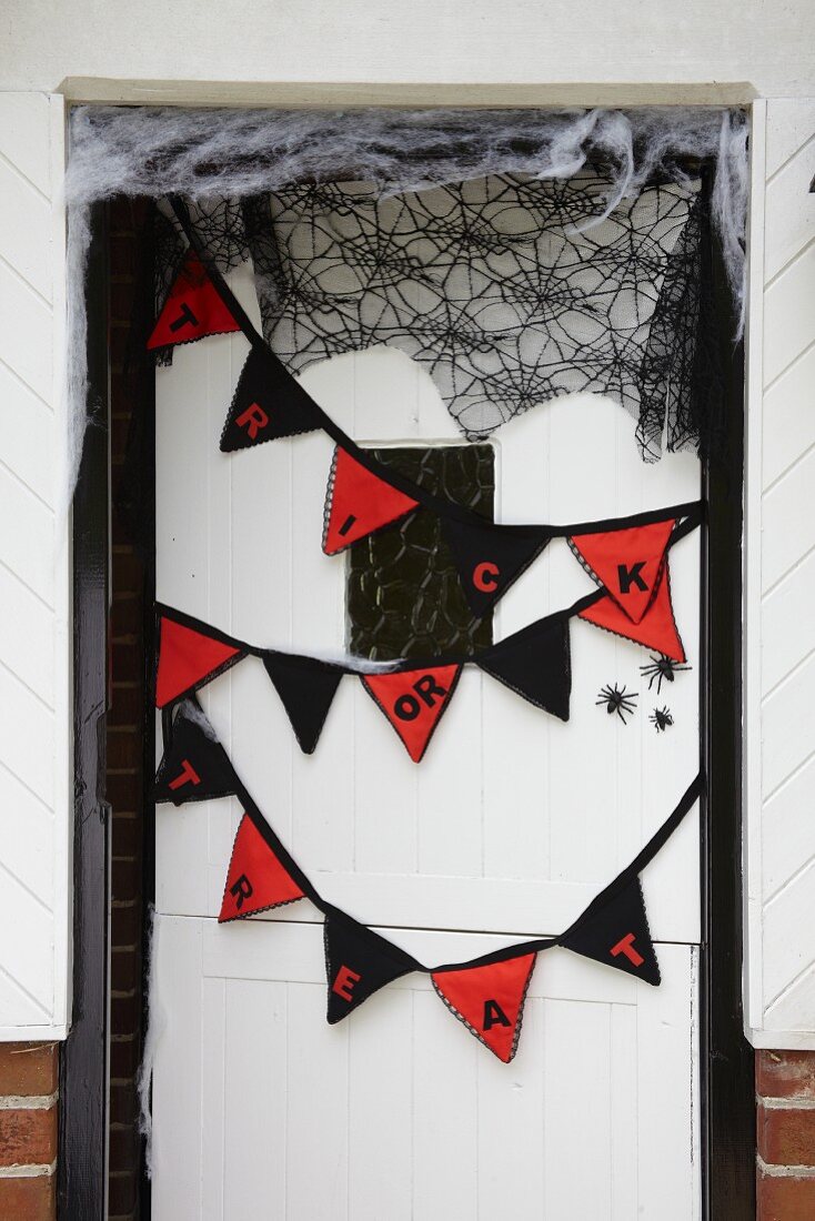 Bunting and spiders' webs on front door as Halloween decorations