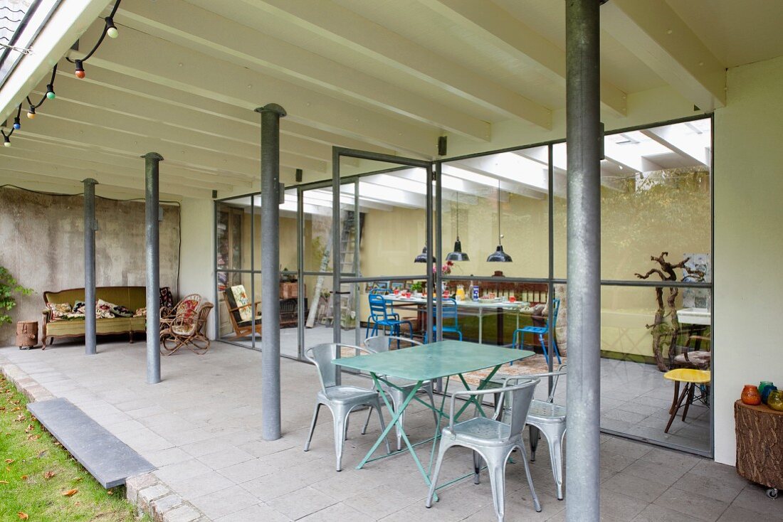 Roofed terrace and conservatory extension with dining areas and various vintage seating