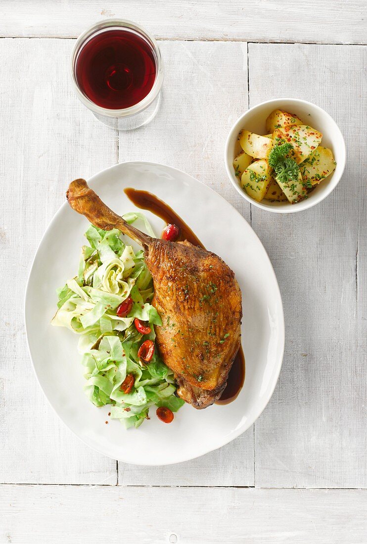 Glazed goose legs with pointed cabbage, chilli peppers, rosehip sauce and a side of potatoes