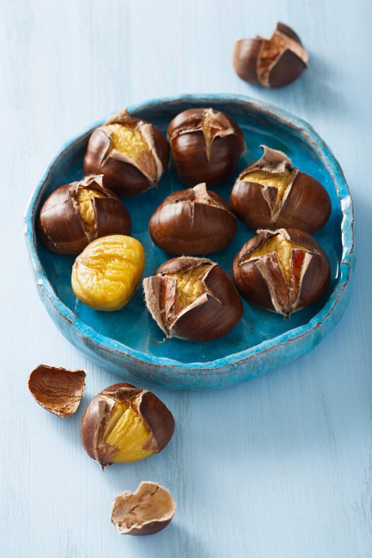 Roasted chestnuts in a blue ceramic bowl