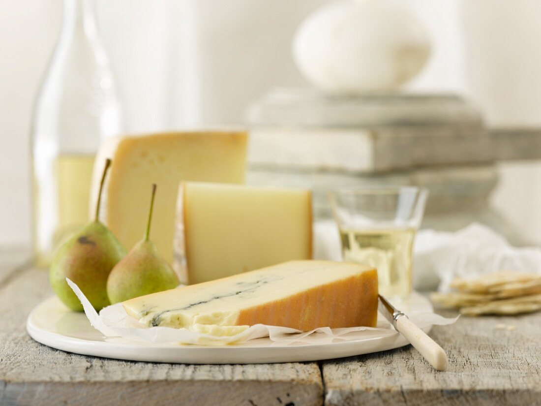 Slices of cheese with pears, crackers and white wine