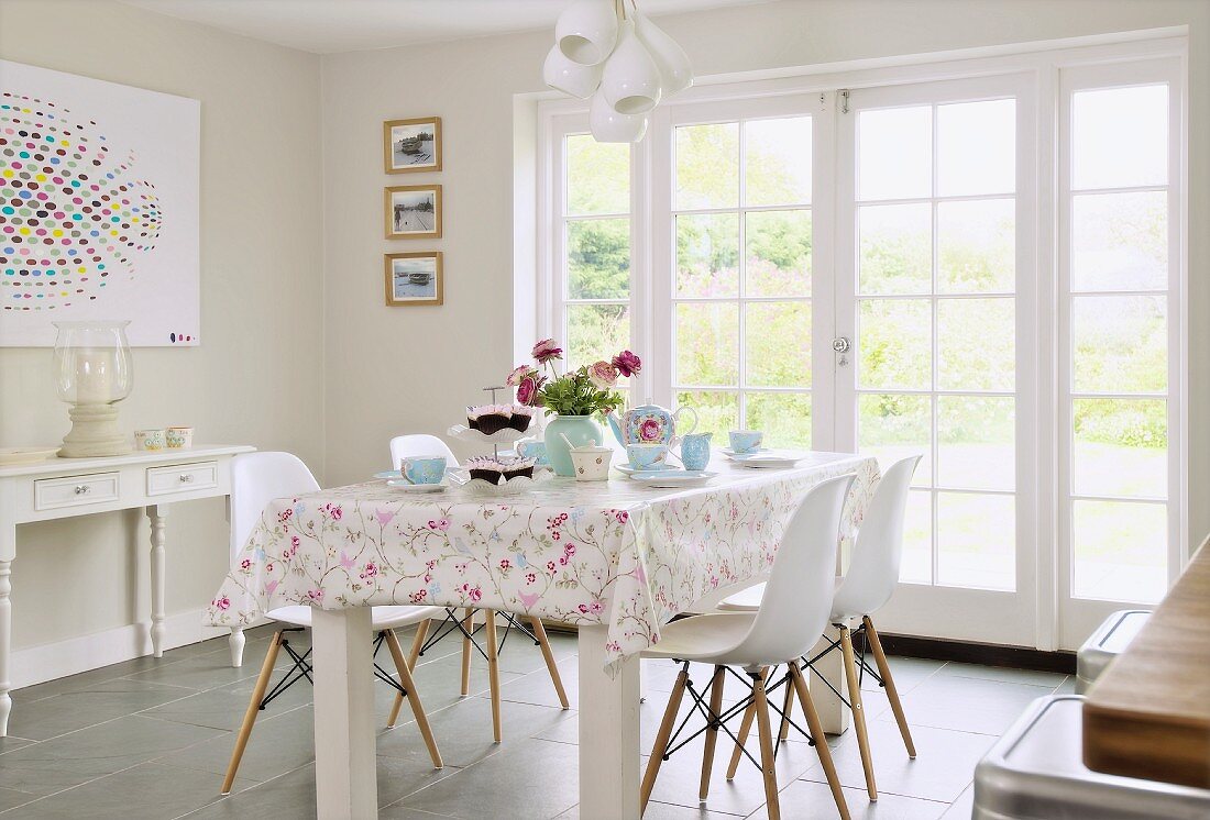 Rustic dining area with white classic chairs in front of terrace doors