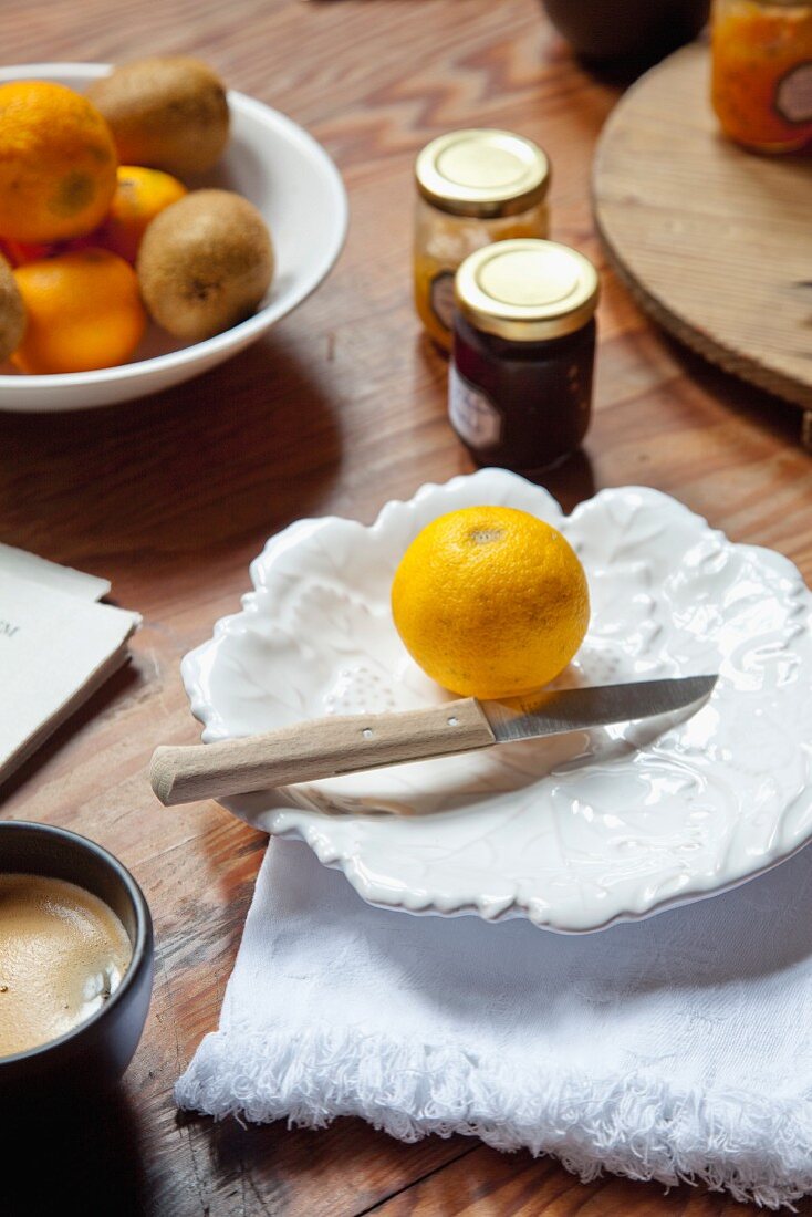 Frische Zitrone und Messer auf weissen Teller in Blattform