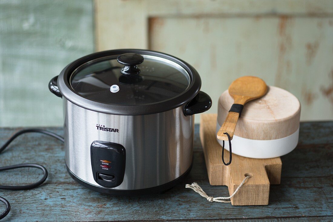 An electric rice cooker and wooden kitchen utensils