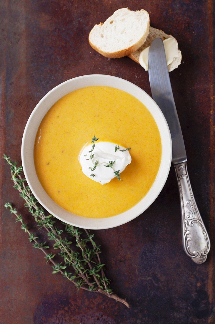 Pumpkin soup with sour cream, thyme and bread