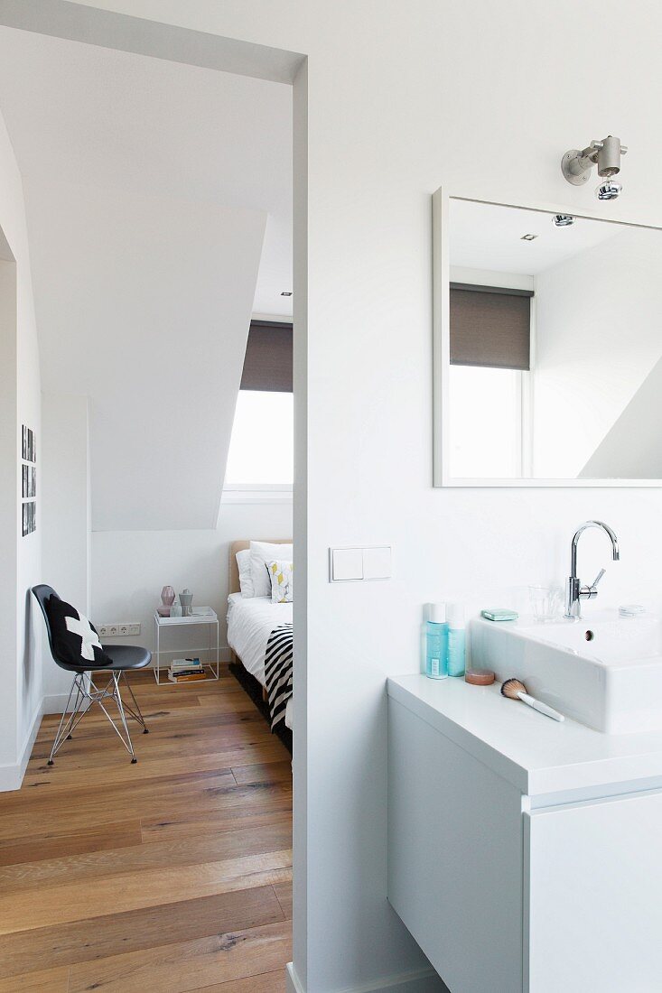 Washstand in bathroom and view of bedroom through open doorway