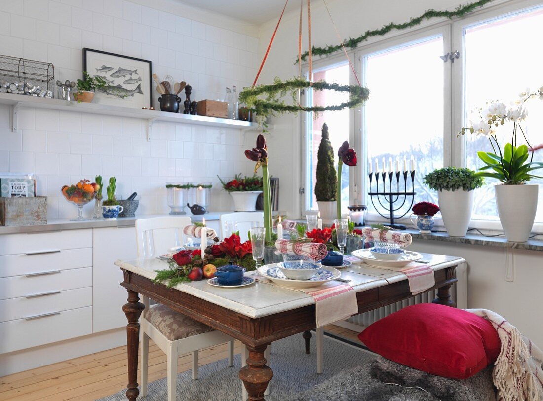 Christmas atmosphere in modern kitchen with Advent wreath above set table