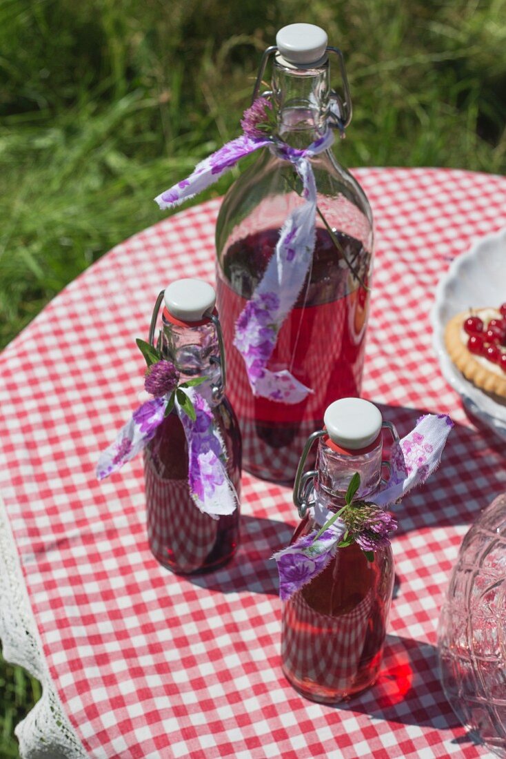 Cherryade in flip-top bottles on a checked tablecloth outside