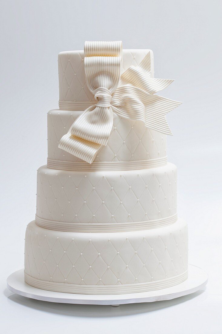 An elegant wedding cake with a white bow