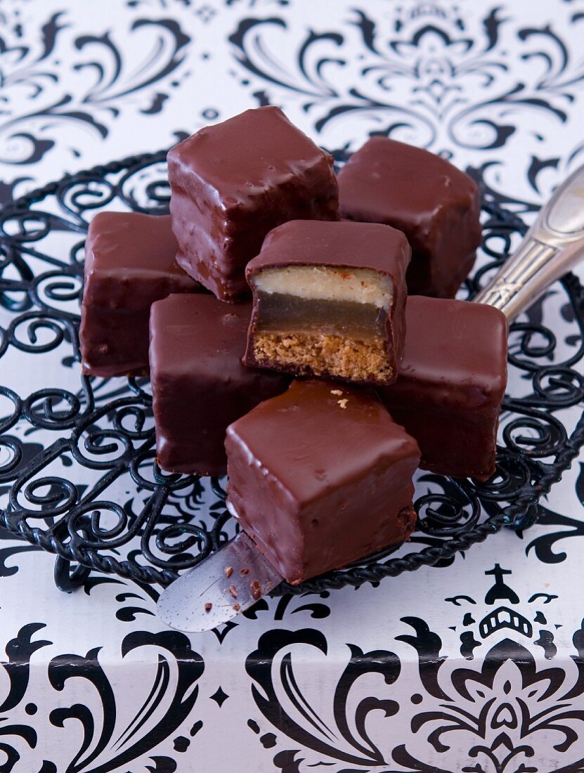 Dominosteine (chocolate covered sweets with marzipan and gingerbread) with a kitchen knife