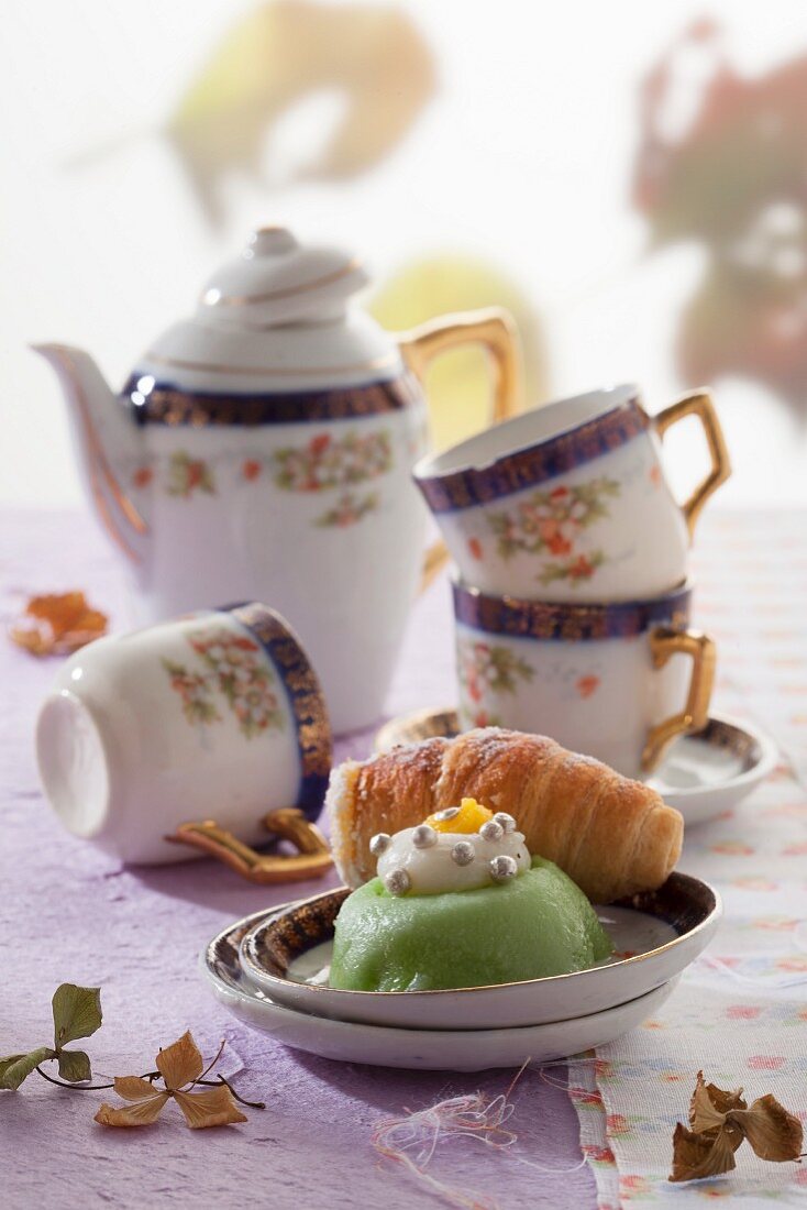 Cassata cake and a puff pastry roll filled with ricotta cream in front of an antique coffee service