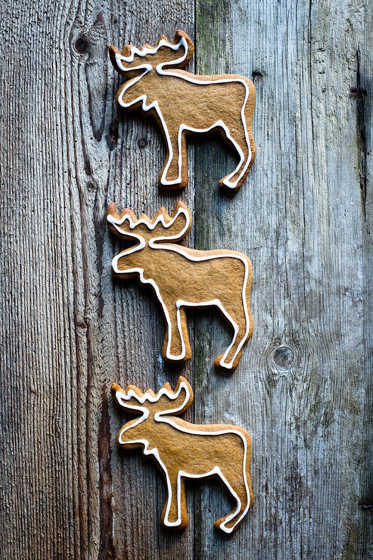 Reindeer-shaped gingerbread biscuits on a wooden surface