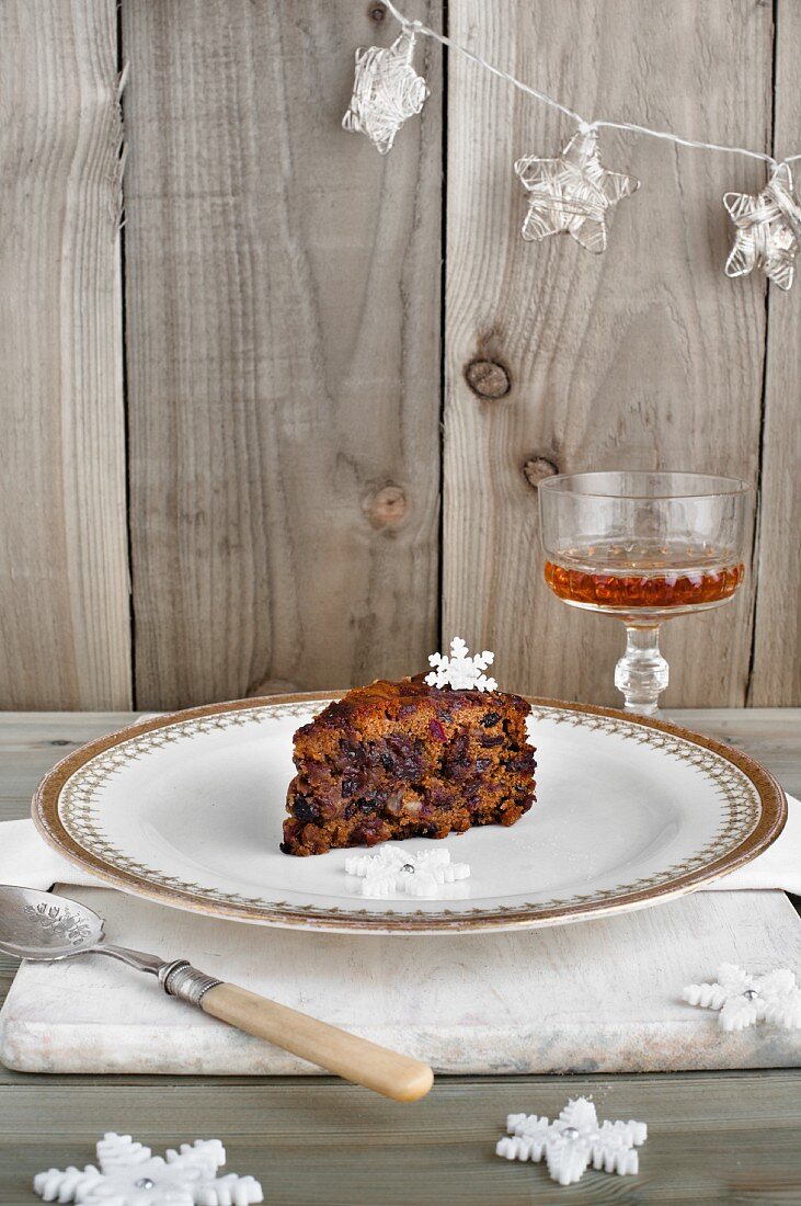 A slice of Christmas fruit cake and a glass of sherry