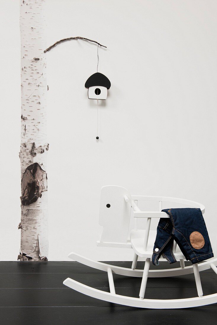 Photo poster of birch trunk with nesting box ornament on branch and rocking horse in foreground