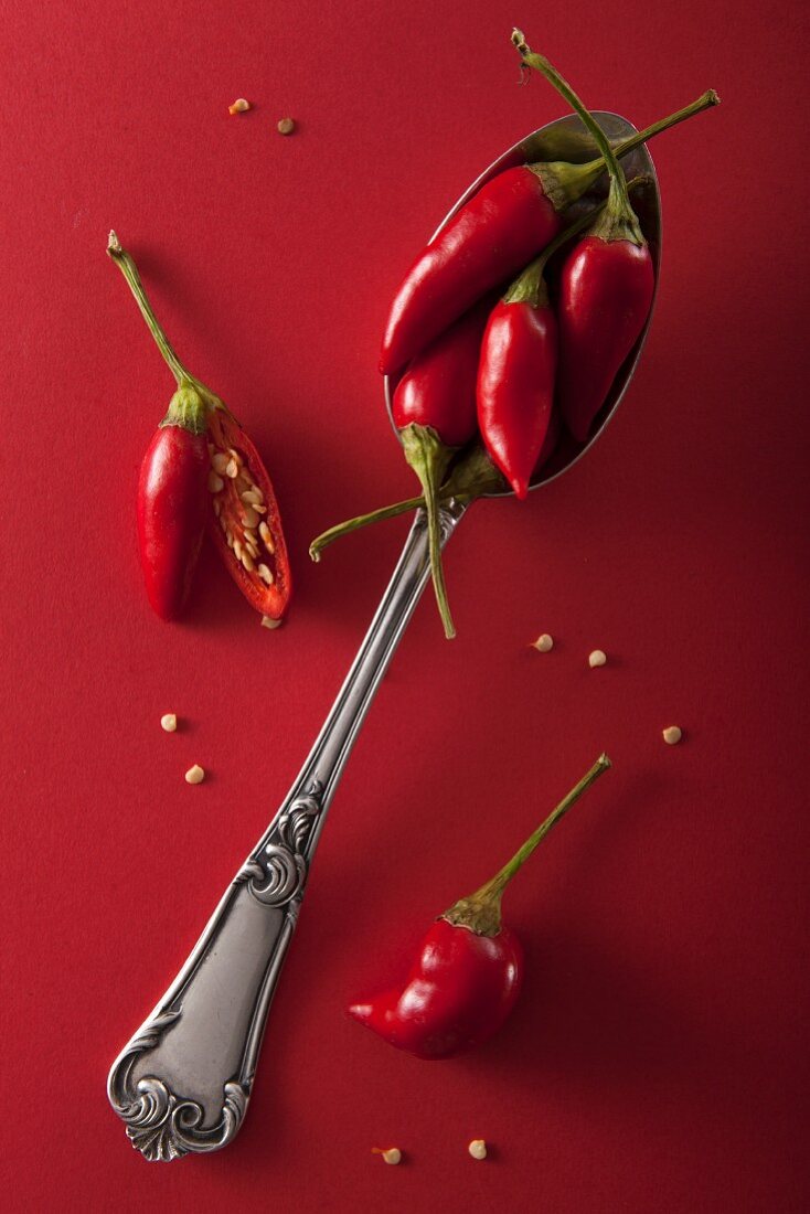 Red chilli peppers on a red surface