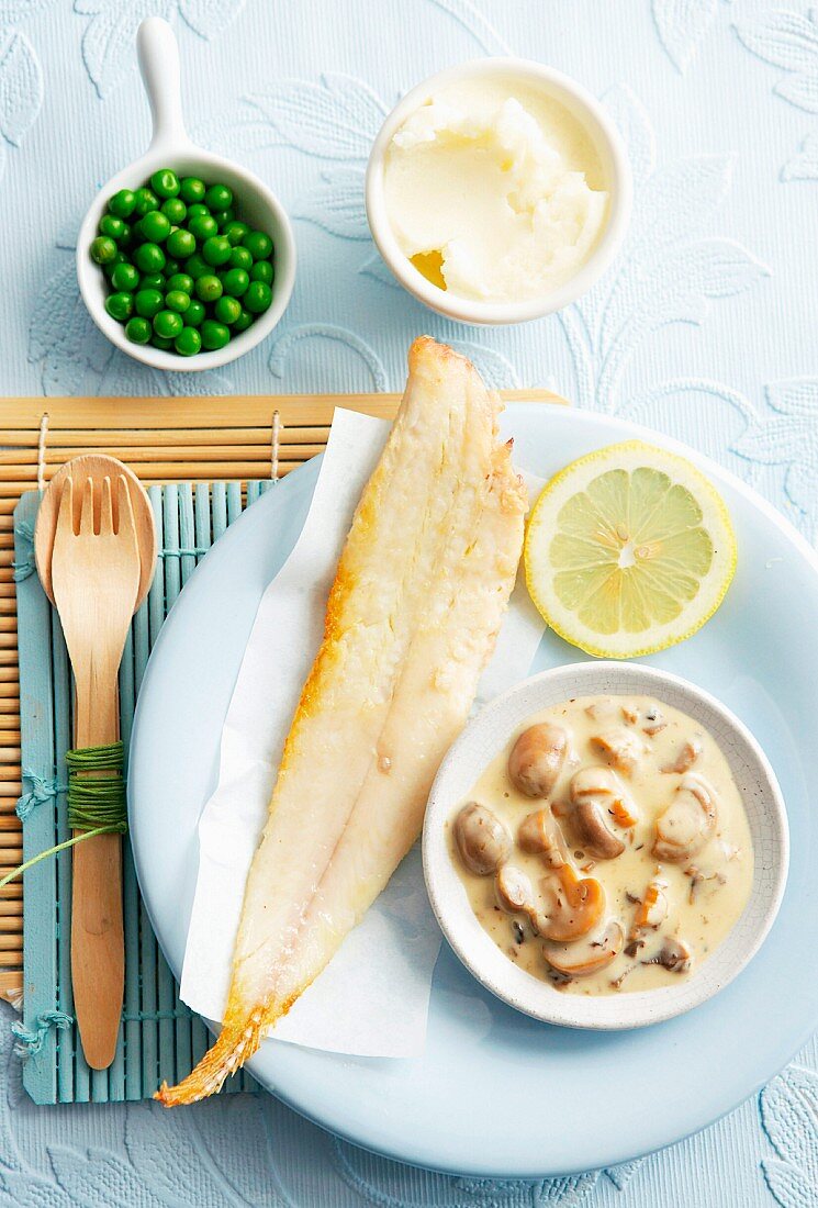 Plaice fillet with a creamy mushrooms sauce, mashed potatoes and peas