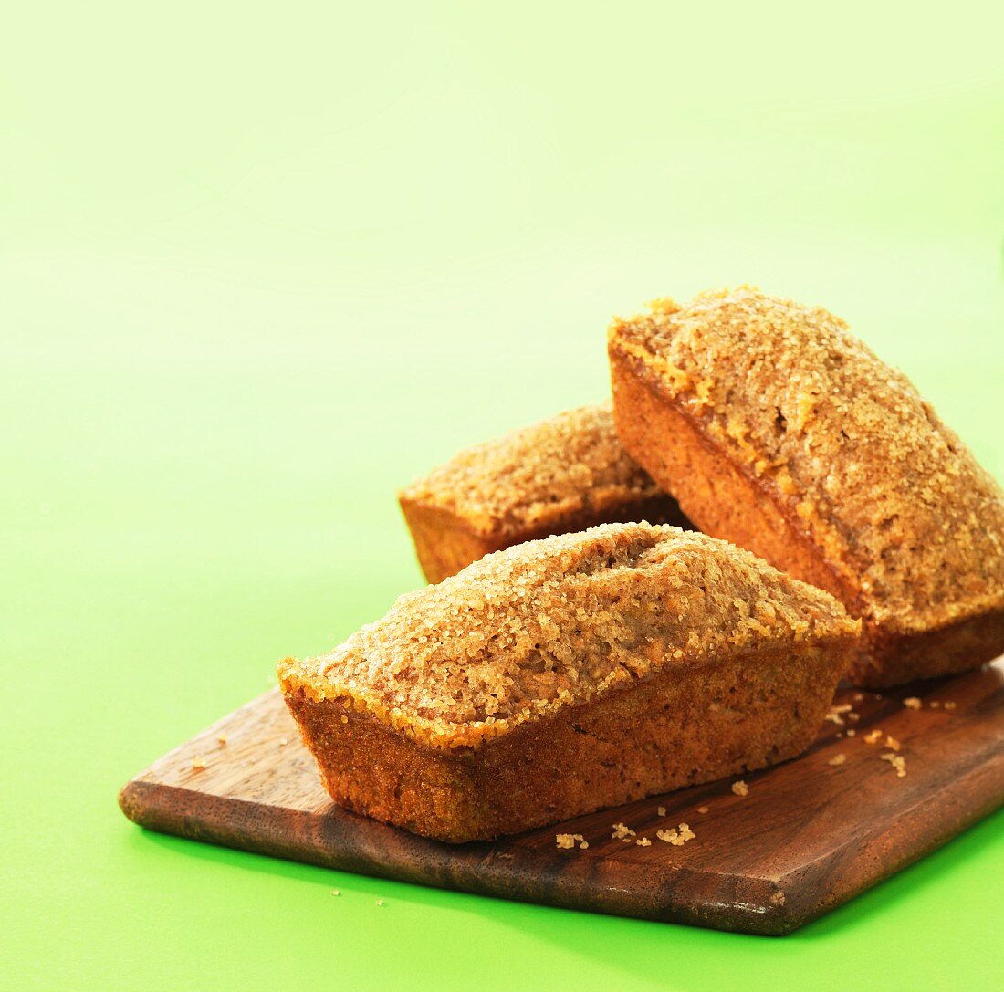 Three loaves of banana bread on a wooden board