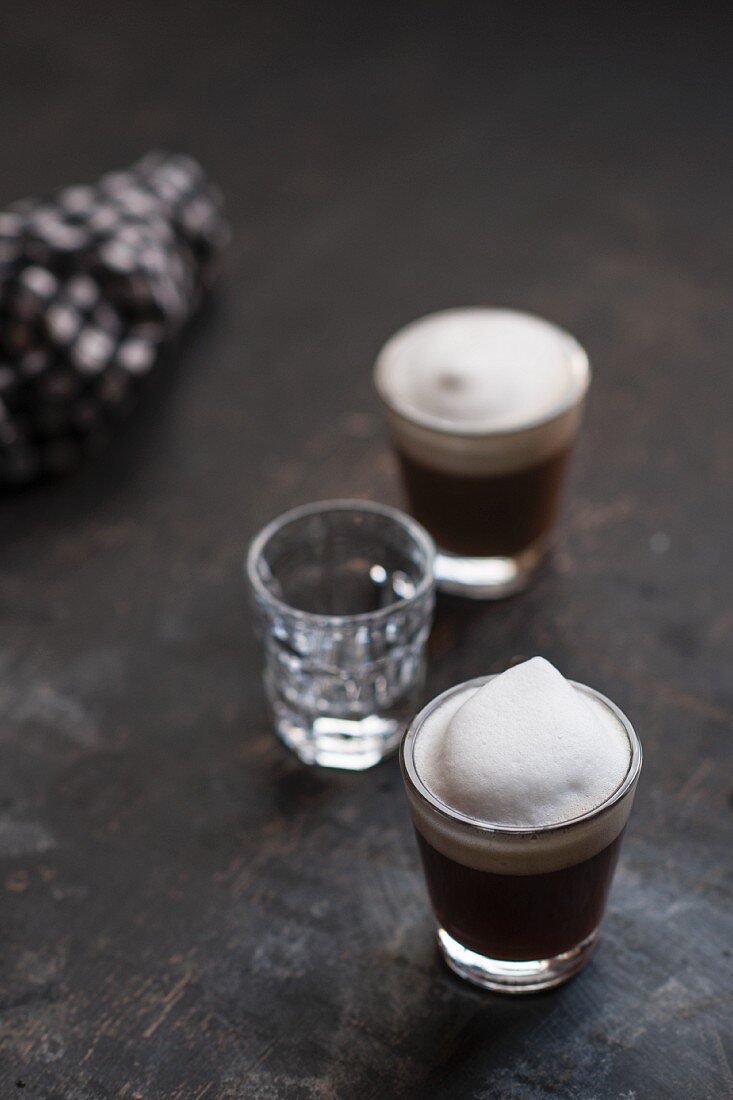 Glasses of espresso topped with milk foam