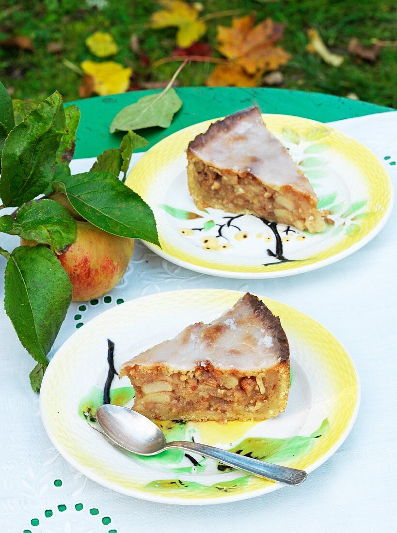 Two slices of layered apple cake on a garden table