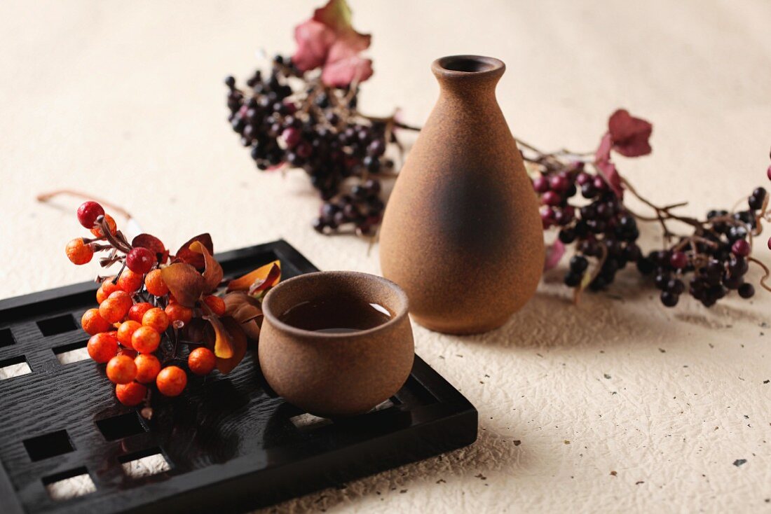 Sake in a bowl and a carafe decorated with berries