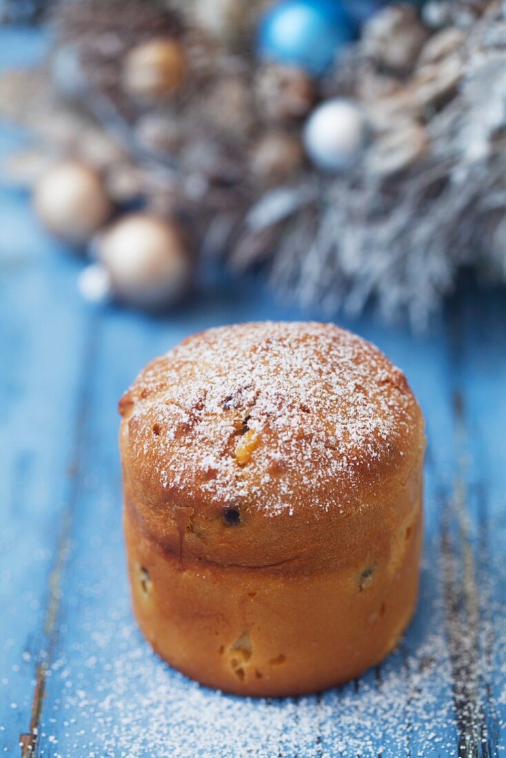 A mini panettone on a blue wooden surface