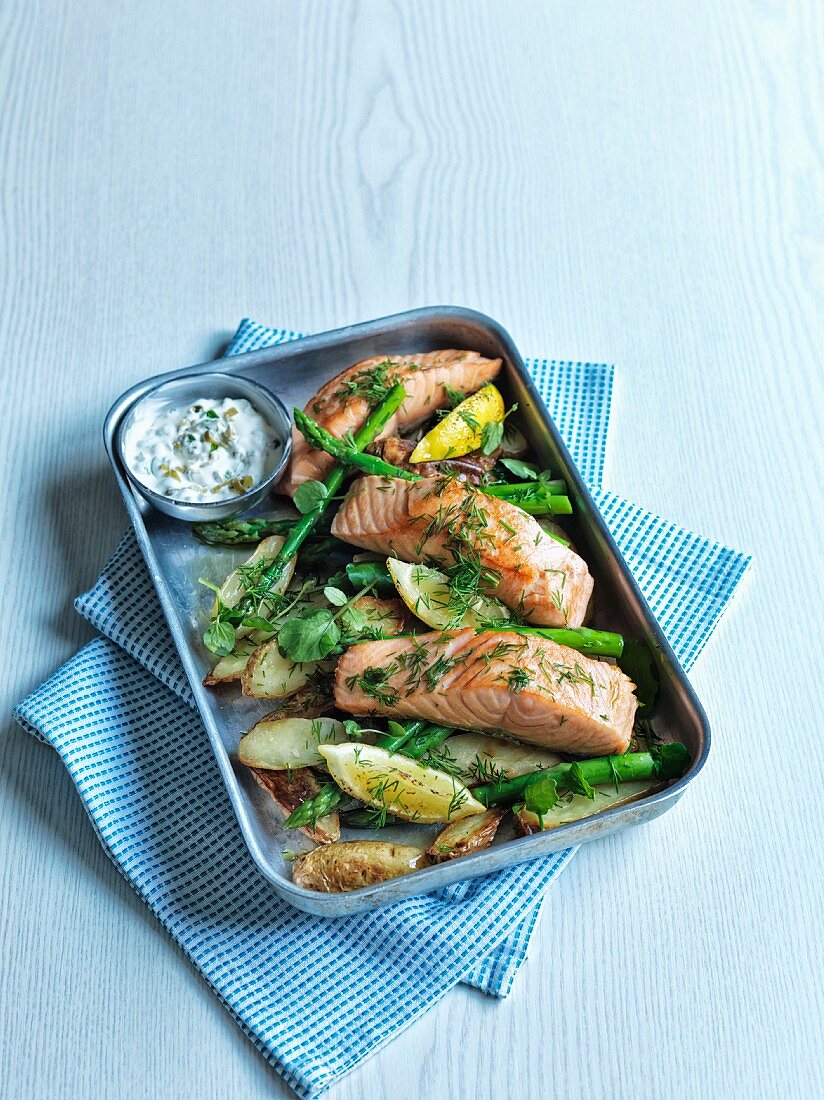 Oven roasted salmon on a bed of potatoes and green asparagus