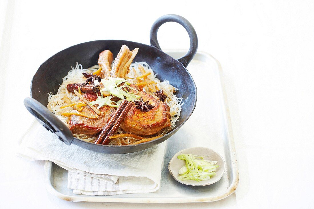 Pork chops with ginger, cinnamon and star anise on noodles