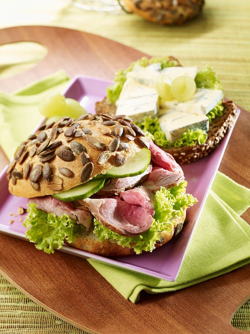 Pumpkin seed rolls with roast beef and protein bread topped with blue cheese