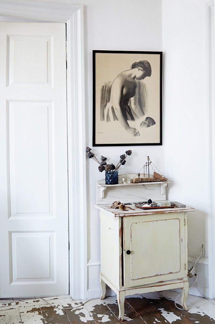 Small, vintage cabinet and wall bracket below framed drawing