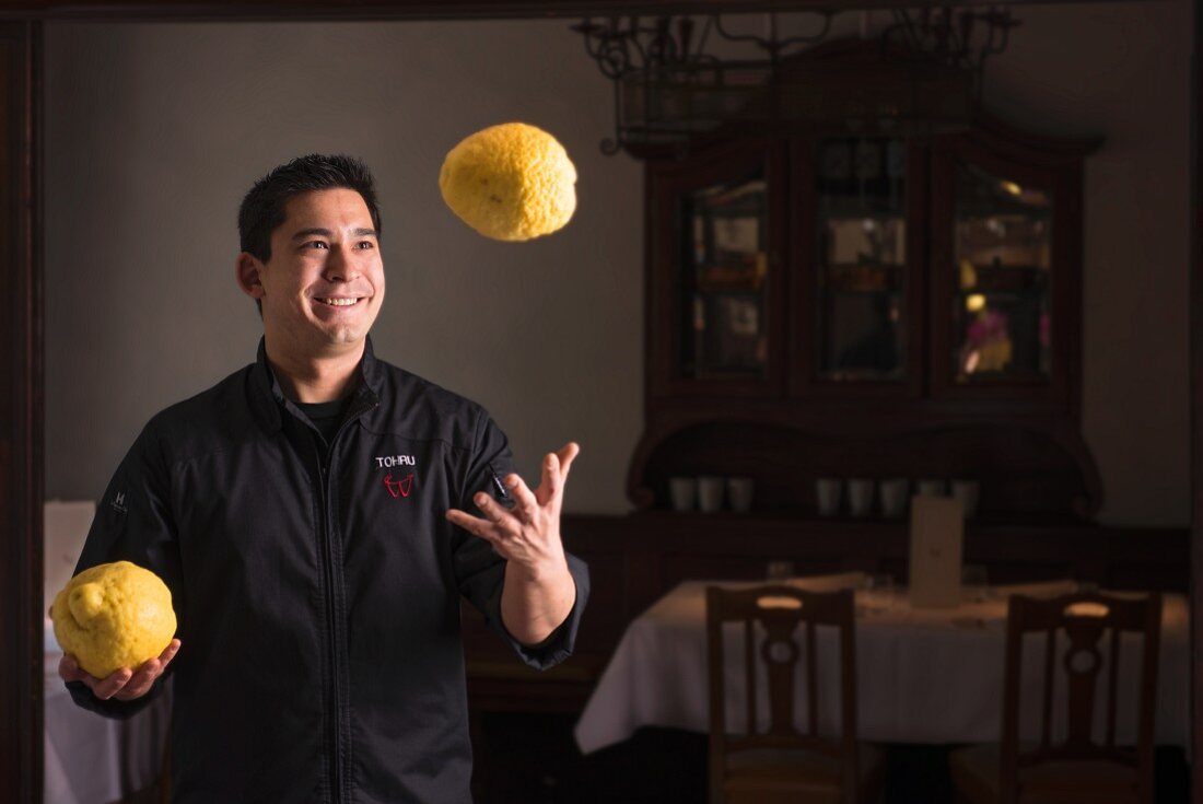 Japanischer Koch jongliert mit Zitronen
