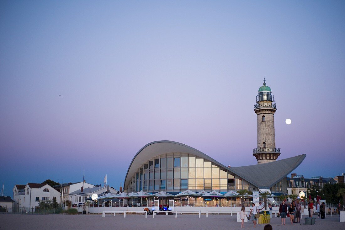 An evening view of the Teepott and the Lighthouse in Warnemünde with a full moon