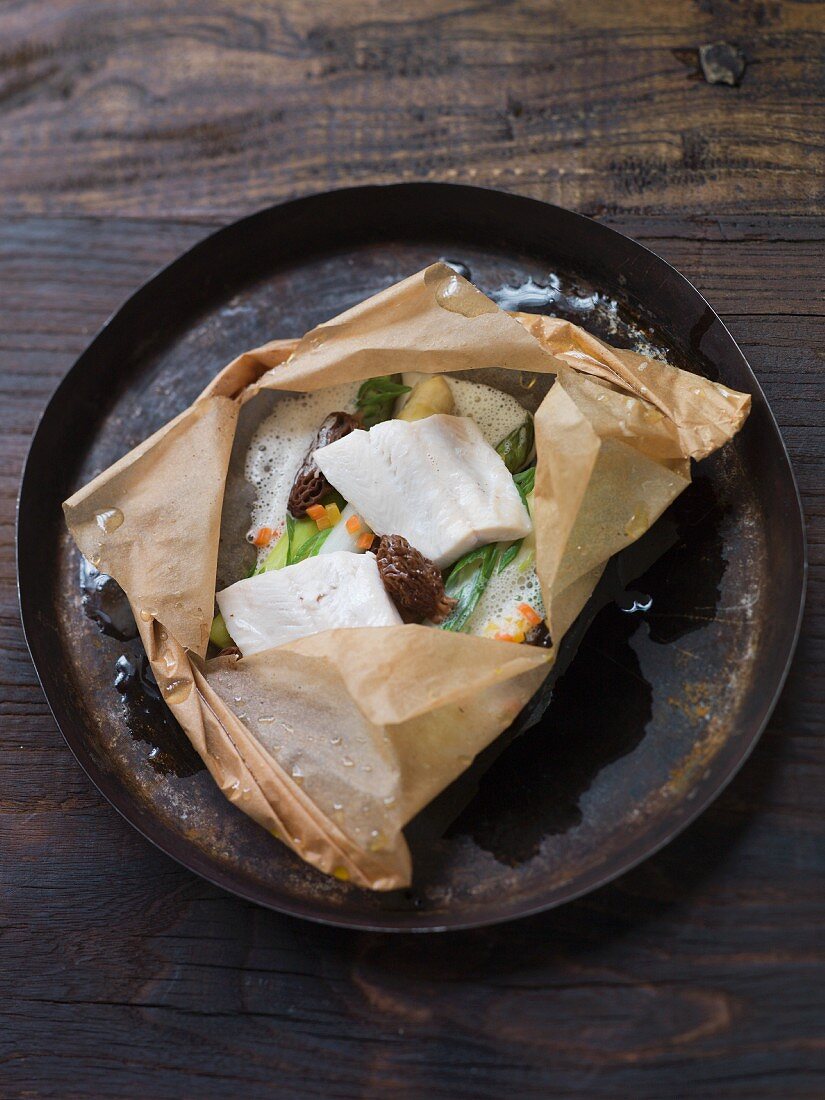 Trout with asparagus and morel mushrooms in baking paper