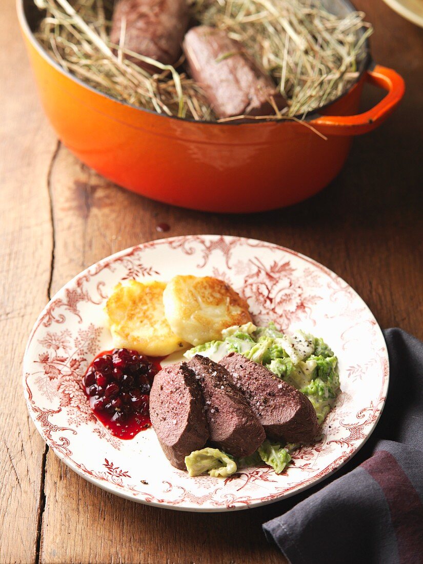 Saddle of chamois with savoy cabbage, potato cakes and cranberries