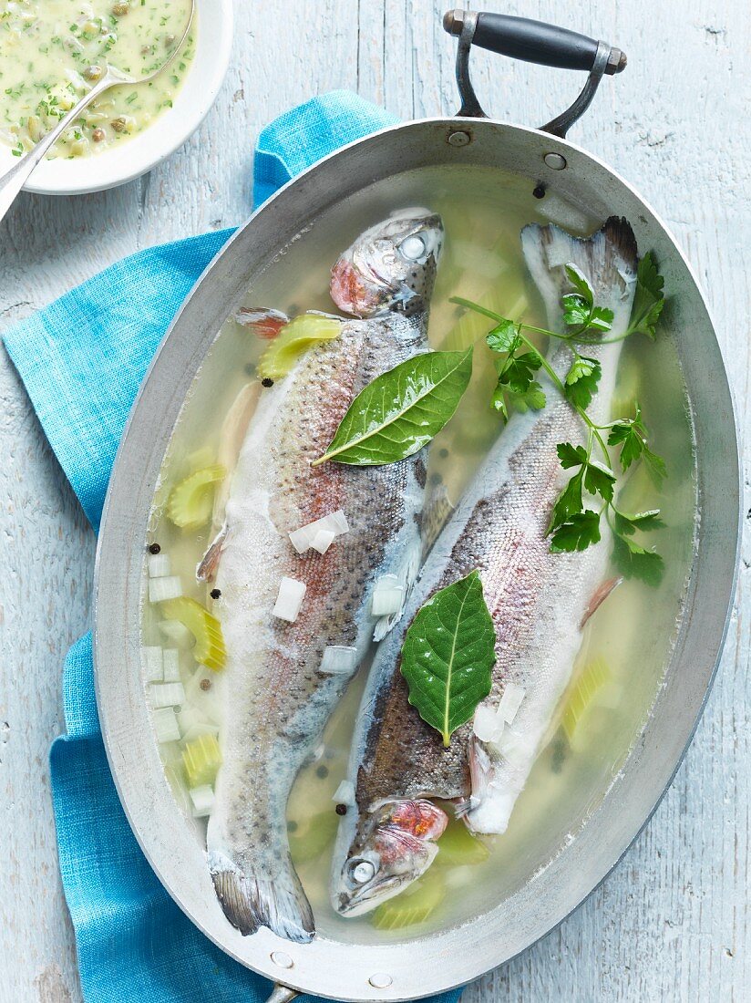 Poached trout in broth served with a mustard and herb sauce