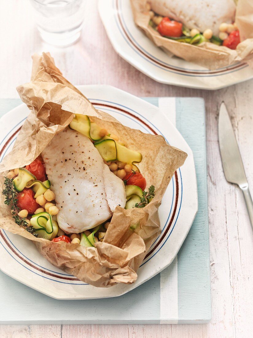 Fish with courgettes, chickpeas and tomatoes in parchment paper