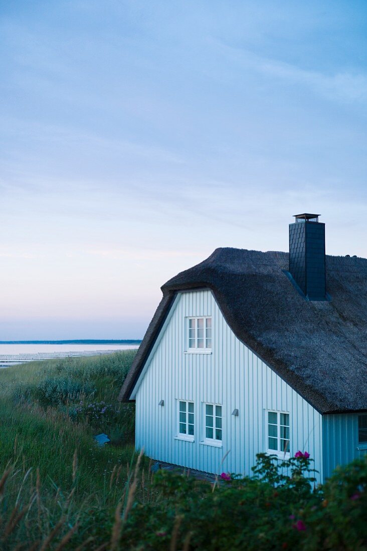 A thatched roof house in Ahrenshoop by dusk on the Baltic Sea