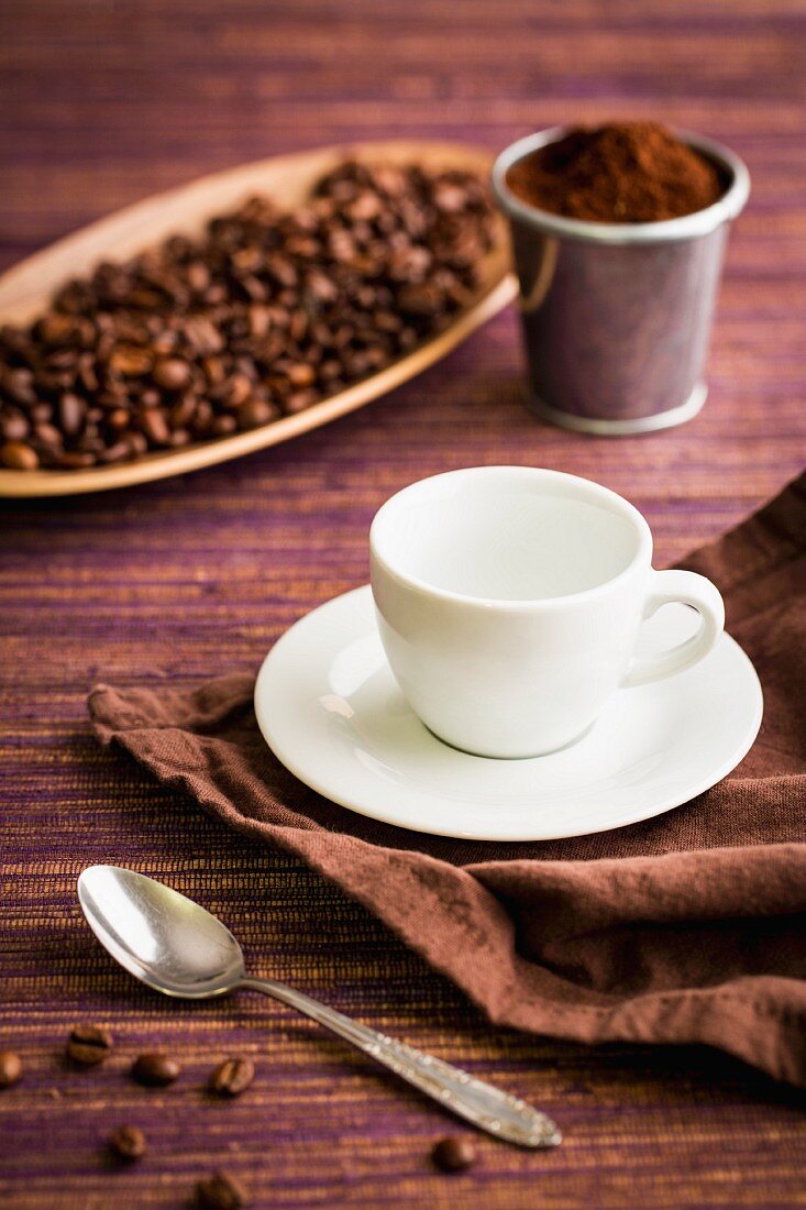 Coffee beans, coffee powder, a coffee cup and a coffee spoon