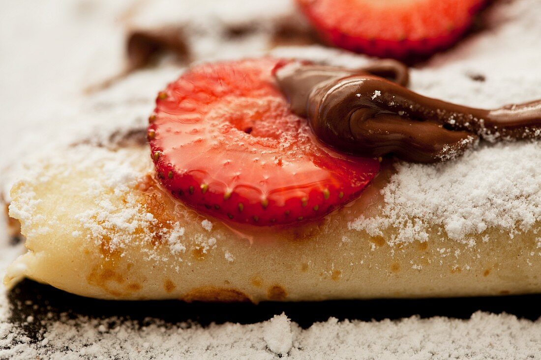 Crepes mit Schokoladensauce und Erdbeeren (Close up)