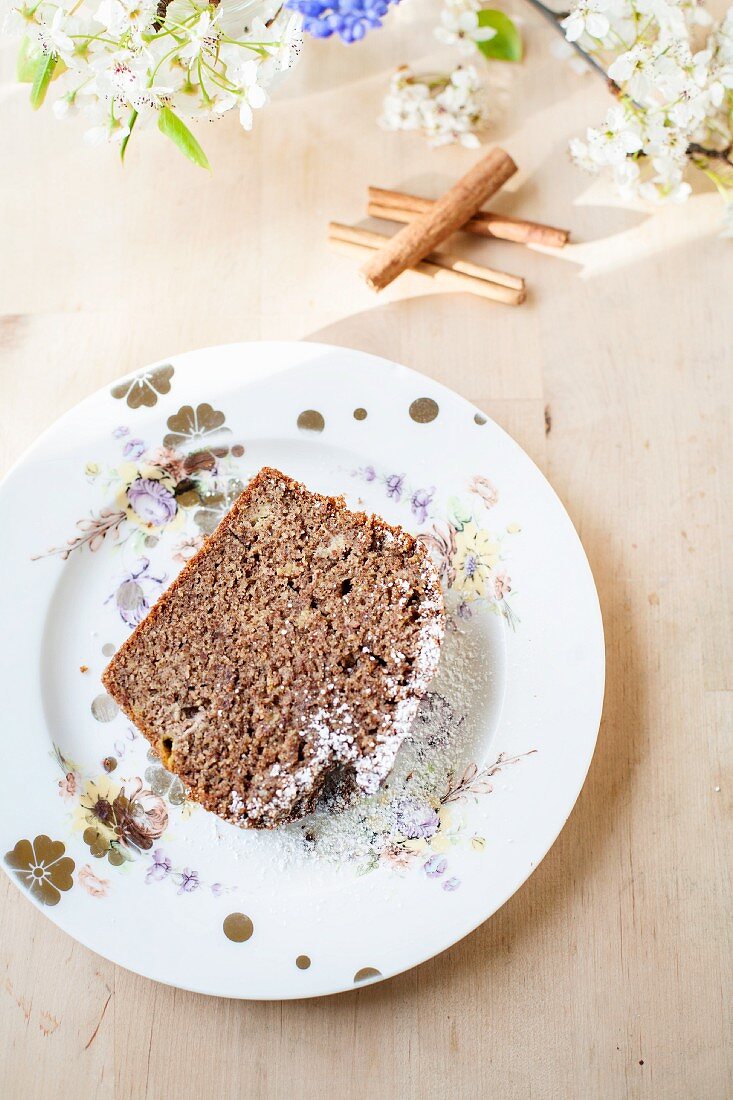 A slice of cinnamon cake with icing sugar