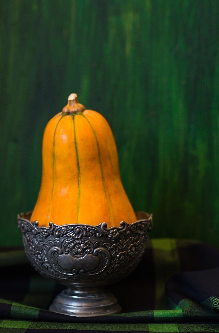 A squash in a pewter bowl