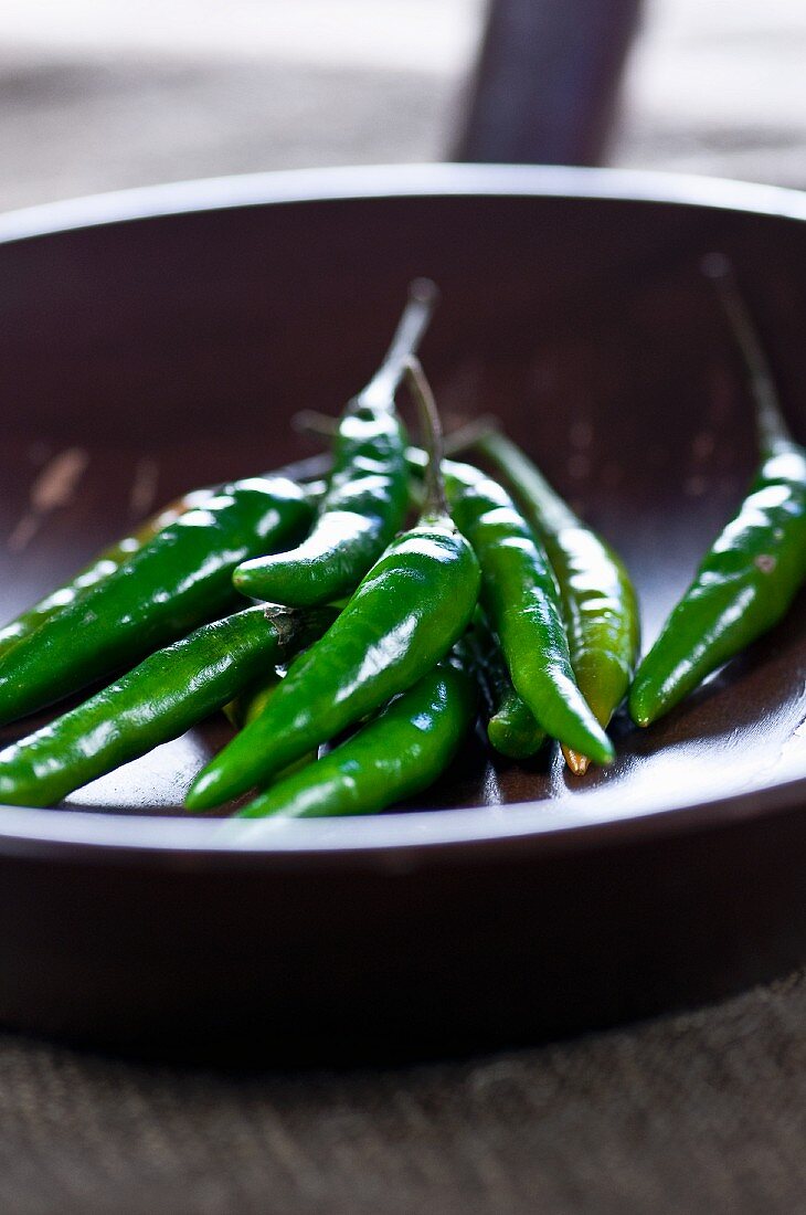 Green chilli peppers in a pan