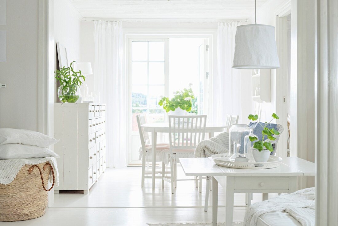 Offener Wohnraum mit weißem Shabby Interieur und grünen Pflanzen