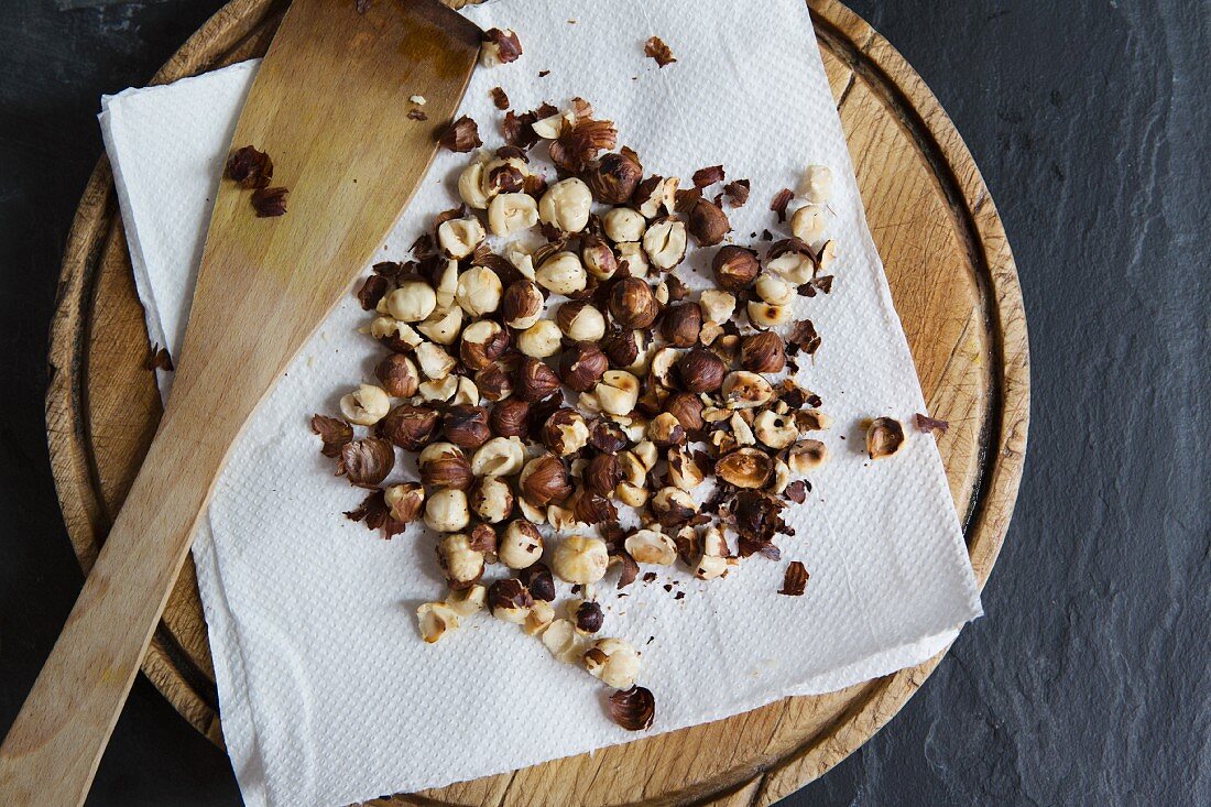 Roasted hazelnuts on a piece of kitchen paper (seen from above)